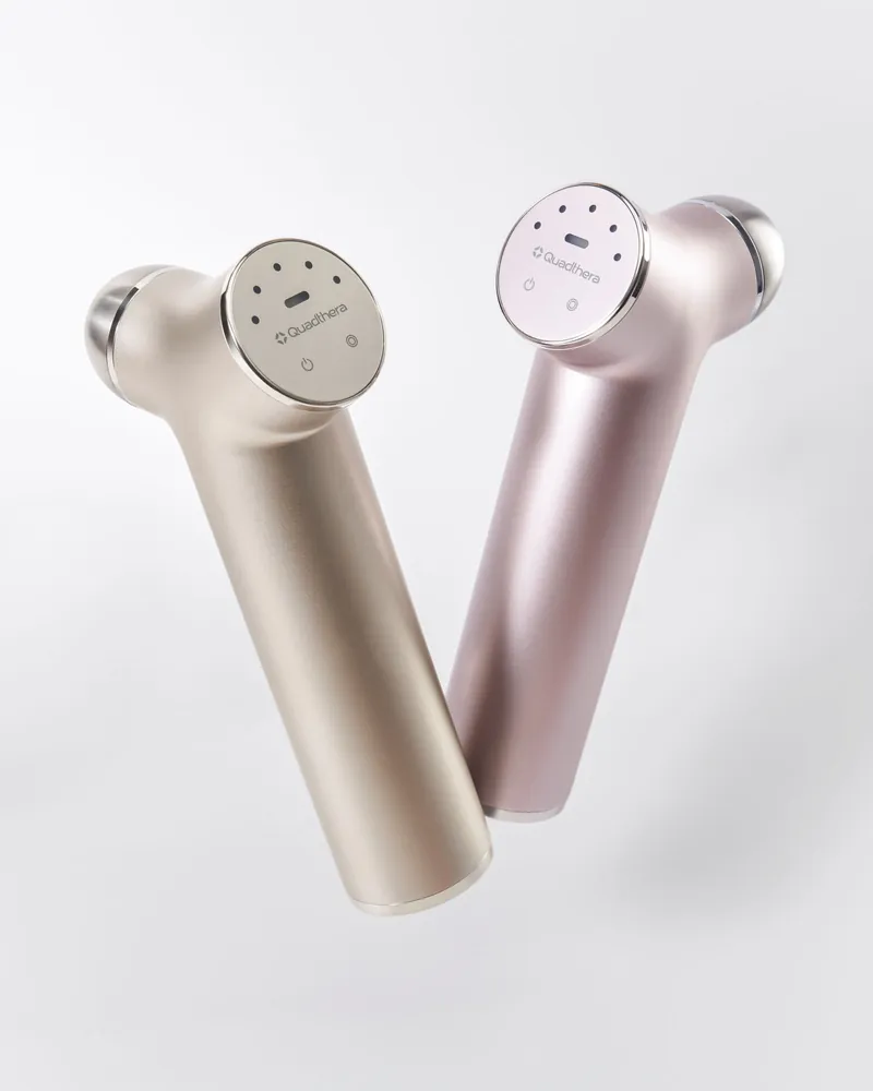 Two Quadthera Titan ultrasonic devices in champagne and rose gold finishes, showing the control panel, on a light background
